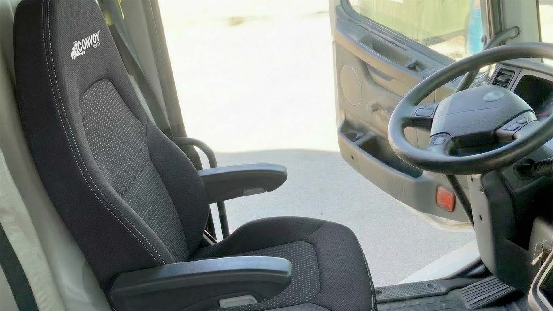 A clean installation of a high-back air-ride replacement Convoy seat inside a commercial truck cab, showcasing the immediate upgrade in quality and professional finish.